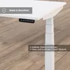 Close-up of a white height-adjustable desk with a control panel and text overlays highlighting features. Produktbild-Vorschau