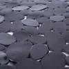 A close-up view of a black and gray pebble-shaped bath mat. Produktbild-Vorschau
