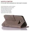 A grey flip case for a smartphone is shown in a stand-up position, displaying text about its features. Produktbild-Vorschau
