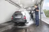A man is washing a car with foam at a car wash. Náhled obrázku produktu