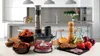 A kitchen scene with an immersion blender and food preparation items. Anteprima dell’immagine prodotto