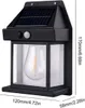 A black solar-powered outdoor wall light with a clear glass lantern and a visible LED bulb inside. Dimensions are shown on the right and bottom of the image. Anteprima dell’immagine prodotto