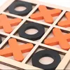 A close-up view of a wooden tic-tac-toe board with orange 'X' pieces and black 'O' pieces. Náhled obrázku produktu