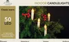 A close-up of LED candle lights on a Christmas tree with red berries. Náhled obrázku produktu