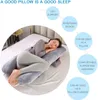 A woman is sleeping on a U-shaped pillow in a bedroom. Náhled obrázku produktu