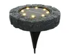 A solar-powered ground light with a stone-like texture. Produktbild-Vorschau