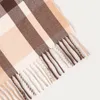 A close-up view of a plaid blanket with fringed edges. Náhled obrázku produktu