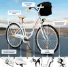 A white city bicycle with a basket is shown outdoors on a road. Produktbild-Vorschau