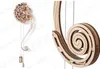 A wooden pendulum clock model, shown in two parts: a detailed close-up of a spiral component and a full view of the clock with its decorative moon-shaped top and pendulum. Voir les images du produit