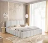 A bedroom scene with a white upholstered bed as the main focus.