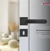 A black door handle set is shown on a door, with a blurred interior scene in the background. Produktbild-Vorschau