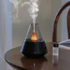 An aroma diffuser with mist emanating from it, placed on a wooden table next to a small bottle of essential oil. Produktbild-Vorschau