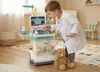 A young boy dressed as a doctor plays with a medical trolley in a room. Anteprima dell’immagine prodotto