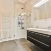 A modern bathroom with a shower, vanity, and towel rack. Anteprima dell’immagine prodotto