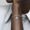 A close-up shot of a person's arm wearing a Pandora bracelet with a blue butterfly charm. Produktbild-Vorschau