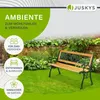 A garden bench is placed on a green lawn in front of a stone wall and lush greenery. Náhled obrázku produktu