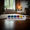 A power strip with multiple outlets and individual switches is placed on a wooden floor in a living room setting. Produktbild-Vorschau
