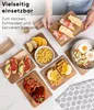 A collection of small wooden cutting boards with various food items arranged on them, including sandwiches, fruit, waffles, and vegetables, with a person's hands holding one of the boards. Náhled obrázku produktu