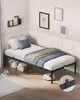 A single bed with bedding in a room setting, featuring a robot vacuum cleaner. Náhled obrázku produktu