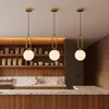 Three modern pendant lights hang above a counter in what appears to be a cafe or retail space. Produktbild-Vorschau