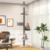 A multi-level cat tree is set up in a living room, with three cats lounging on different platforms. The cat tree is tall and extends to the ceiling, featuring various perches, a basket, and a hammock. The room has a sofa, framed artwork on the wall, and a  Produktbild-Vorschau