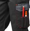 Close-up of a black work pant pocket with red stitching, holding a red pencil and an orange marker. Podgląd zdjęcia produktu