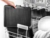 A hand is holding a black grill pan over a dishwasher rack filled with dishes. Podgląd zdjęcia produktu