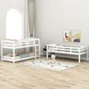 A bedroom scene with multiple white wooden beds, including a bunk bed and a single bed, arranged on a wooden floor with a rug and artwork on the wall. Náhled obrázku produktu