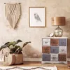 A cozy and bohemian-styled room corner with a wooden dresser, a plant, and wall decor. Podgląd zdjęcia produktu
