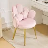 A pink velvet chair with gold legs sits on a rug in front of a white vanity. Náhľad obrázku produktu