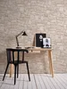 A desk with a lamp, chair, and artwork against a stone wall. Náhľad obrázku produktu
