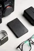 A flat lay of tech accessories including a camera, power bank, smartwatch, and glasses. Produktbild-Vorschau