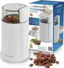 A coffee grinder and its packaging are shown, along with coffee beans. Podgląd zdjęcia produktu