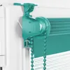 Close-up of a turquoise roller blind mechanism attached to a white window frame. Produktbild-Vorschau