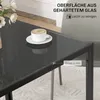 A close-up of a modern dining table with a cup of coffee on it, highlighting its glass surface and metal legs. Produktbild-Vorschau