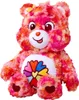 A stuffed toy bear with a colorful flower on its chest. Anteprima dell’immagine prodotto