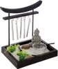 A miniature Zen garden with a Buddha statue, raked sand, and wind chimes. Anteprima dell’immagine prodotto