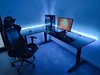 A gaming desk setup with a computer, monitor, and chair, illuminated by blue LED lighting. Anteprima dell’immagine prodotto