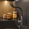 A kitchen sink area with a flexible black faucet and jars of food items on the counter. Anteprima dell’immagine prodotto