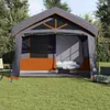 A large family tent set up on a grassy lawn with trees in the background. Produktbild-Vorschau