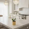 A modern kitchen island with a gold planter holding white orchids. Náhled obrázku produktu