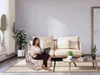 A woman is sitting on a foldable mattress, working on her laptop, in a living room setting. Anteprima dell’immagine prodotto