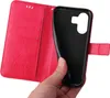 A hand holding a red flip phone case, showing the inside compartment. Produktbild-Vorschau