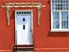 A wooden pergola-style awning over a red house door and window. Podgląd zdjęcia produktu