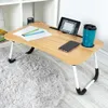 A portable lap desk with a tablet, phone, pens, and a cup on it, placed on a fluffy rug. Produktbild-Vorschau