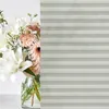 A bouquet of flowers in a vase is partially obscured by a pleated blind. Produktbild-Vorschau