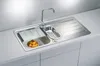 A stainless steel kitchen sink with a faucet, a cutting board, a drainer basket, and a bowl of oranges. Produktbild-Vorschau