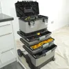 A multi-tiered rolling tool chest with its top lid open, placed on a white tarp. Voir les images du produit
