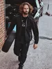 A man is carrying a tire in a garage or workshop setting. Produktbild-Vorschau