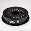 A black bundt cake pan with white speckles sits on a light gray surface. Anteprima dell’immagine prodotto